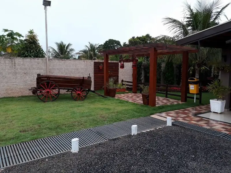 Carro de boi decorativo e pérgola no jardim ao entardecer