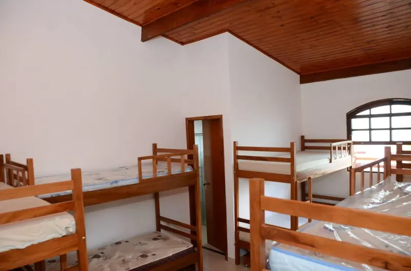 Suíte com forro de madeira, beliches e cama de solteiro